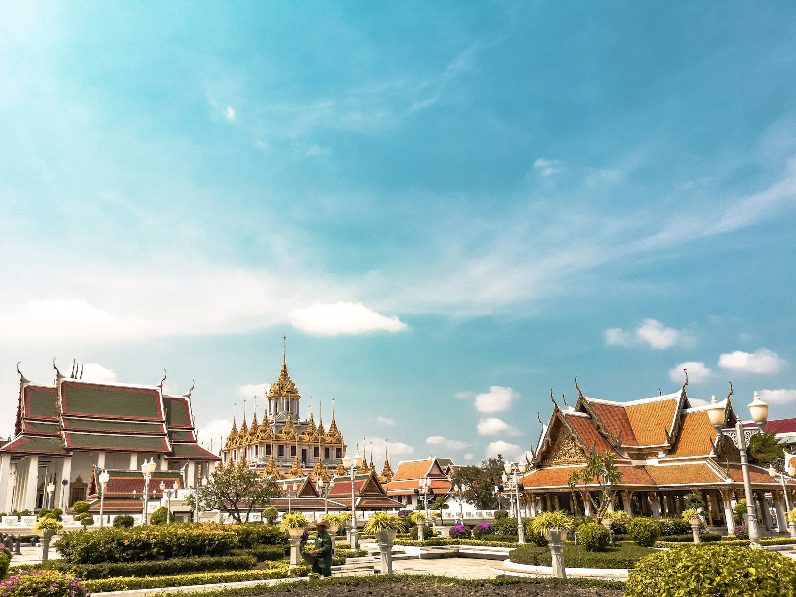 Ornate Thai temple roofs and golden details under tropical light
